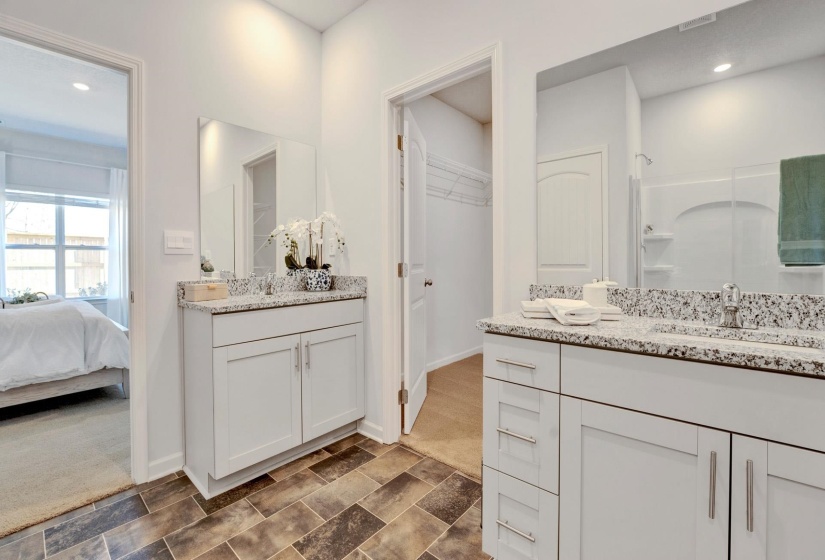 Full bathroom with two vanities, recessed lighting, a spacious closet, a shower stall, and ensuite bathroom