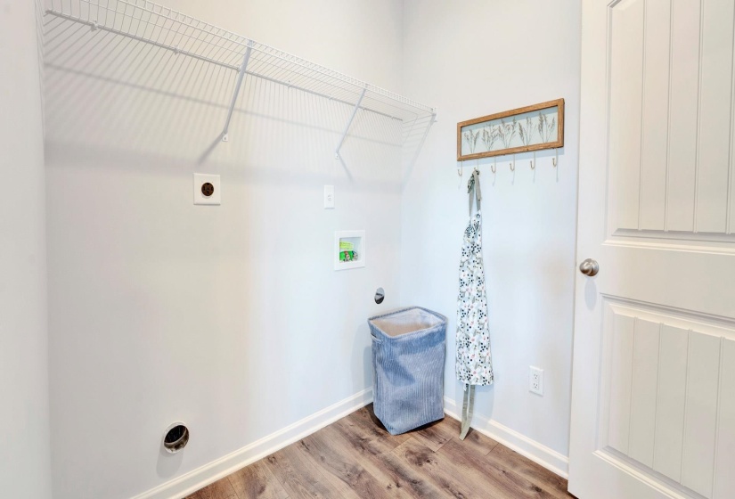 Laundry area with electric dryer hookup, wood finished floors, and washer hookup