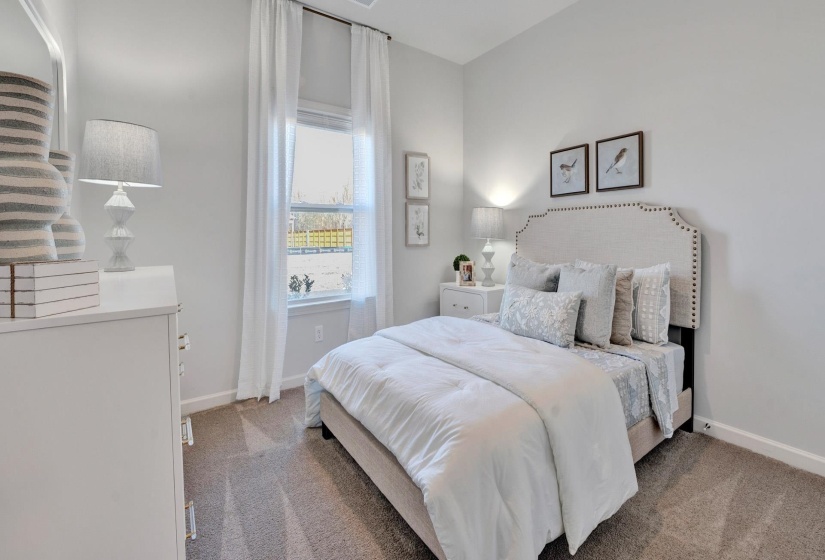 Bedroom with light colored carpet and baseboards