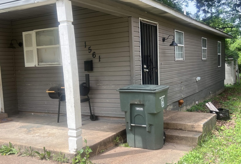 Front exterior featuring horizontal siding, a covered porch with a support column, and a concrete entryway with steps