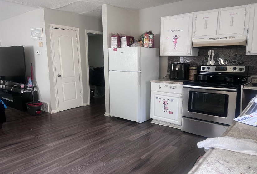 Kitchen area featuring white cabinetry, a stainless steel range, and a white refrigerator