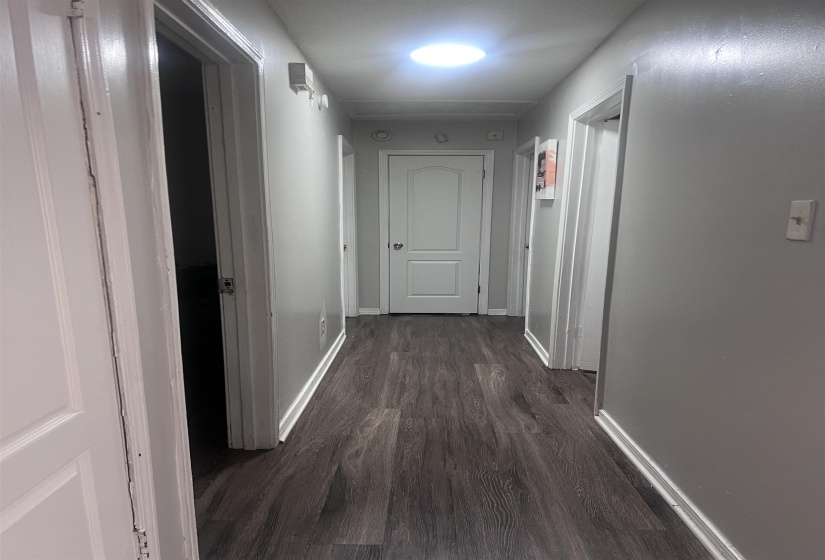 Hallway featuring wood-finish flooring and light gray painted walls