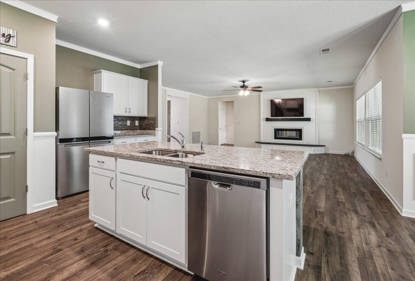 Kitchen island with an undermount double basin sink and a stainless steel dishwasher