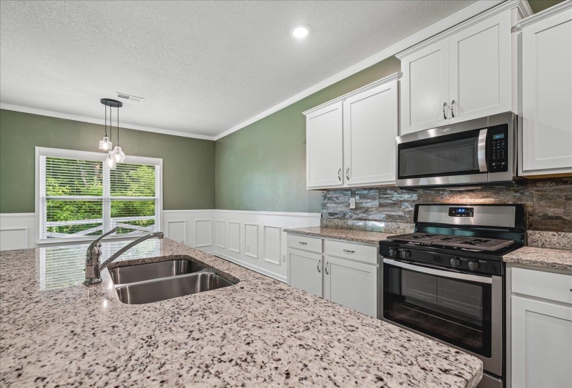 Kitchen island with a double basin stainless steel sink and gooseneck faucet