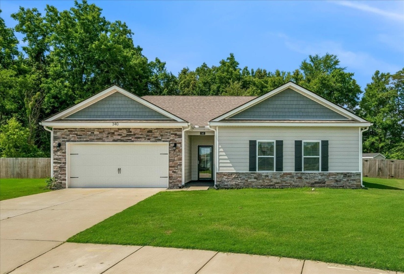 Single-story residence featuring a two-car garage, stone veneer accents, and gray siding