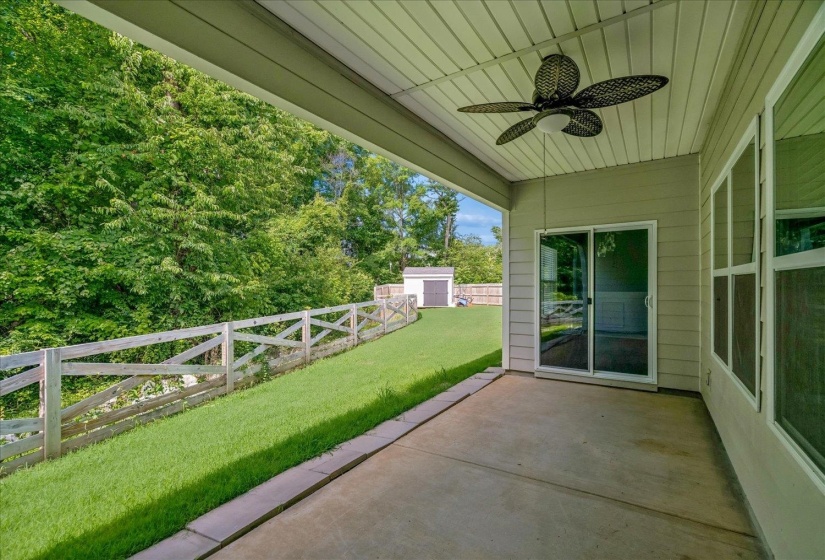 Covered patio featuring a ceiling fan with integrated lighting, concrete flooring, and sliding glass door access