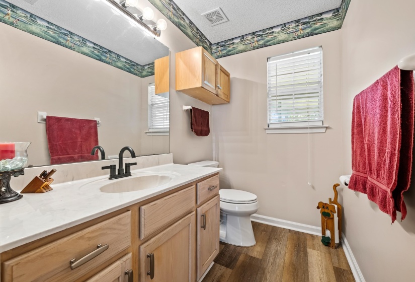 Bathroom featuring a vanity with light wood cabinetry, white countertop, and a black-finished faucet