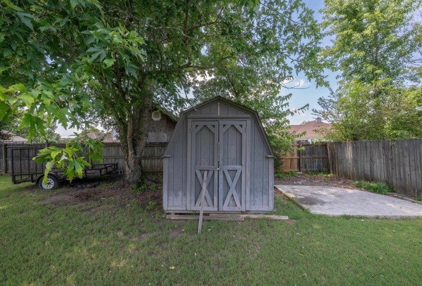 Exterior storage shed with double barn doors, wood siding, and a gabled roof