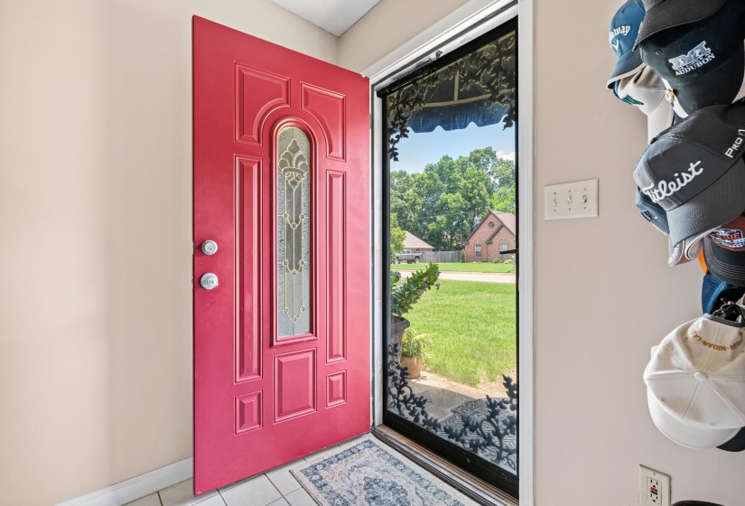 Vibrant red entry door featuring decorative glass insert