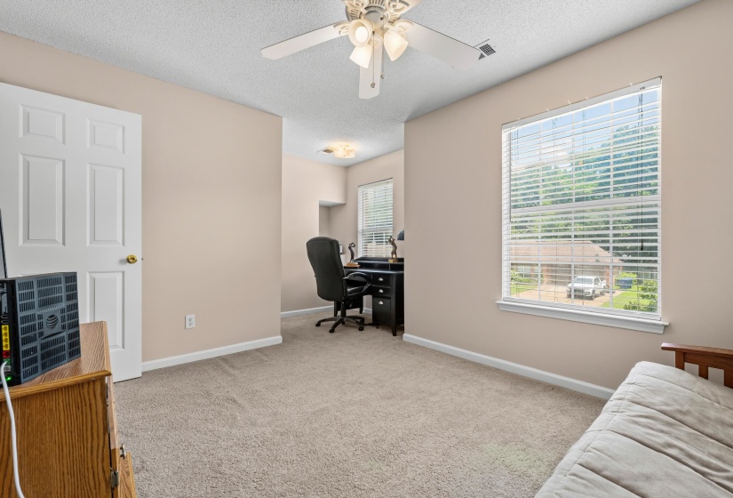 Carpeted room with neutral wall paint and a ceiling fan with integrated lighting