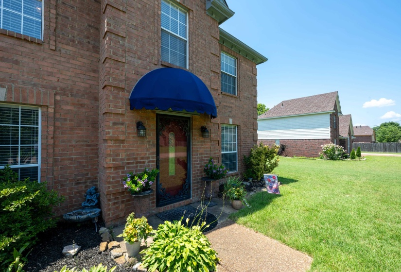 Brick facade featuring a deep blue awning over the entryway