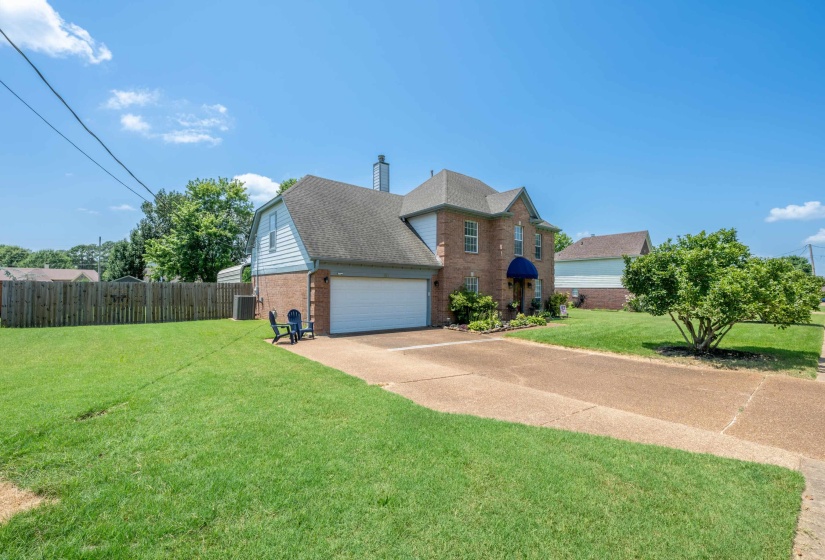 Brick and siding exterior featuring a prominent gabled roofline, attached garage with a white door, and a paved driveway