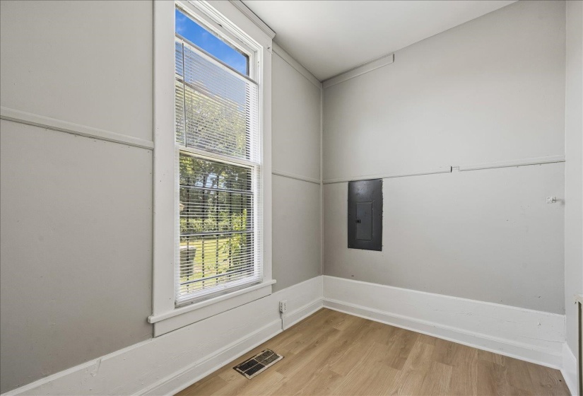 Room with wood-finish flooring, white baseboards, and light gray walls