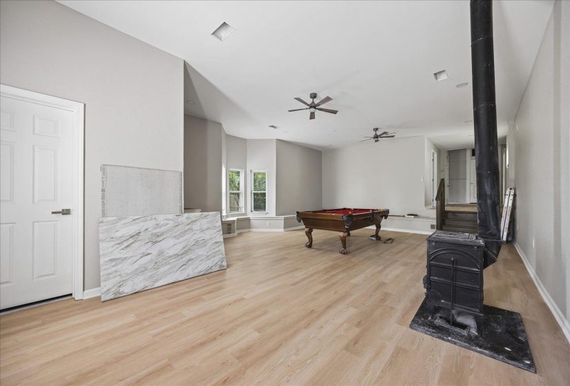 Expansive room featuring wood-finish flooring, recessed lighting, and multiple ceiling fans