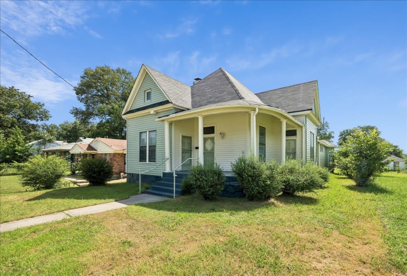 Traditional style residence featuring a covered front porch, light blue siding, a gabled roofline, and established front yard landscaping