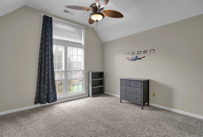 Unfurnished bedroom with carpet flooring, vaulted ceiling, and a ceiling fan