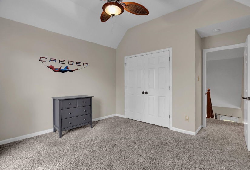 Unfurnished bedroom with vaulted ceiling, carpet flooring, ceiling fan, and a closet