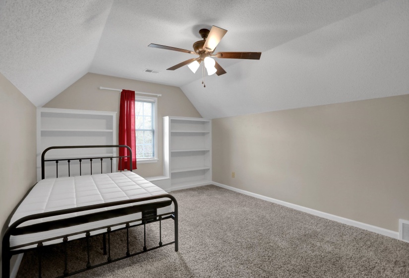 Bedroom with light colored carpet, a textured ceiling, and ceiling fan
