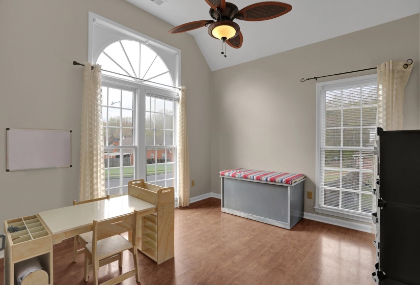 Dining room featuring ceiling fan, light wood-style flooring, vaulted ceiling, and healthy amount of natural light