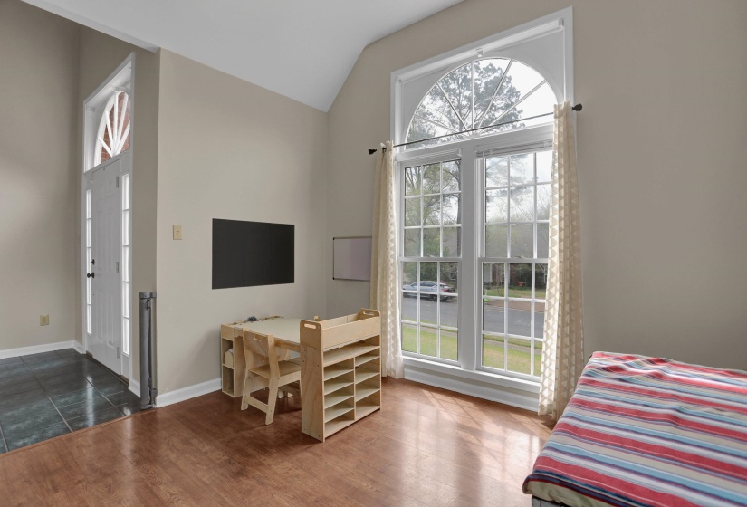 Bedroom with lofted ceiling and wood finished floors