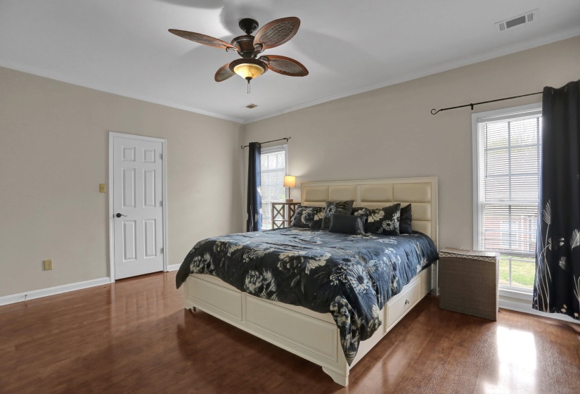 Bedroom with crown molding, ceiling fan, and dark wood finished floors