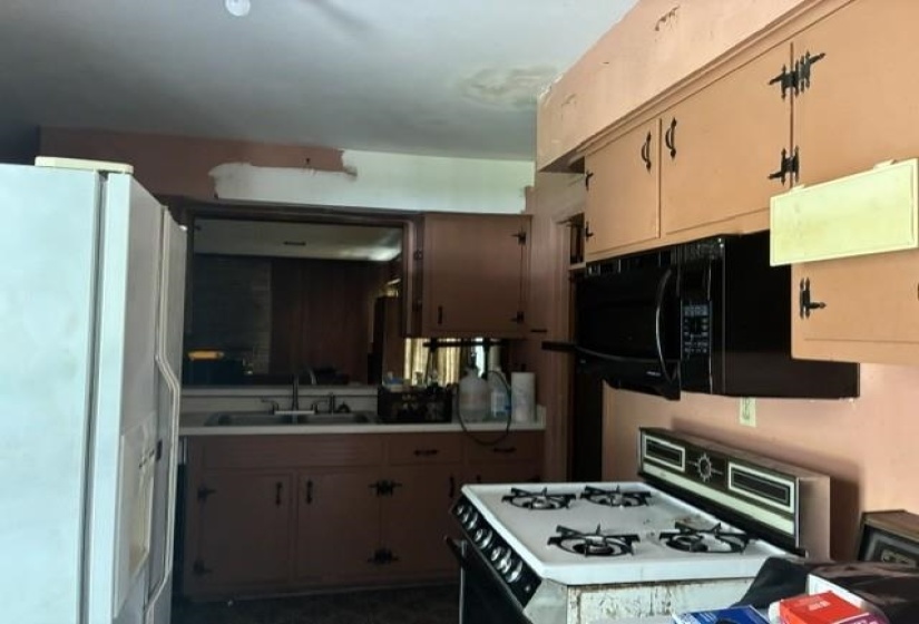 Kitchen featuring upper and lower cabinetry, a double-basin sink, and an overhead microwave