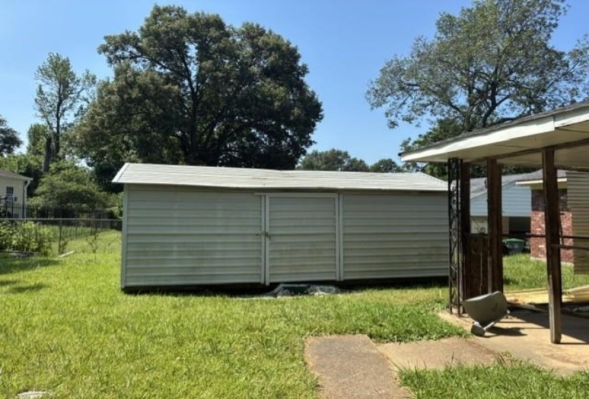 Detached storage shed with siding exterior and a sloped roof