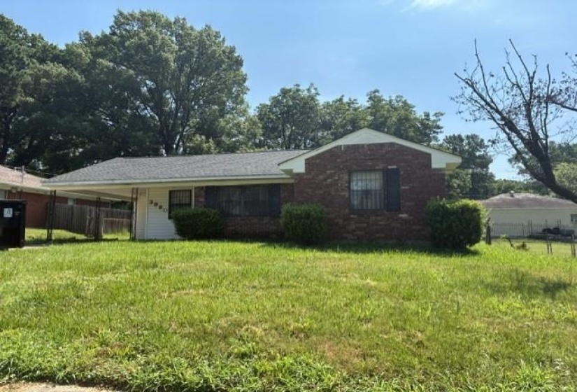 Brick and siding exterior featuring a covered carport