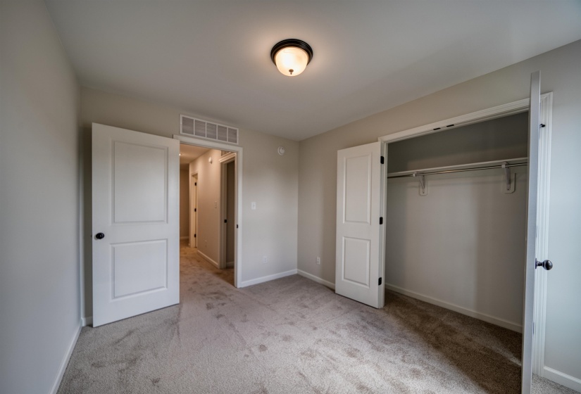 Unfurnished bedroom featuring light carpet and a closet