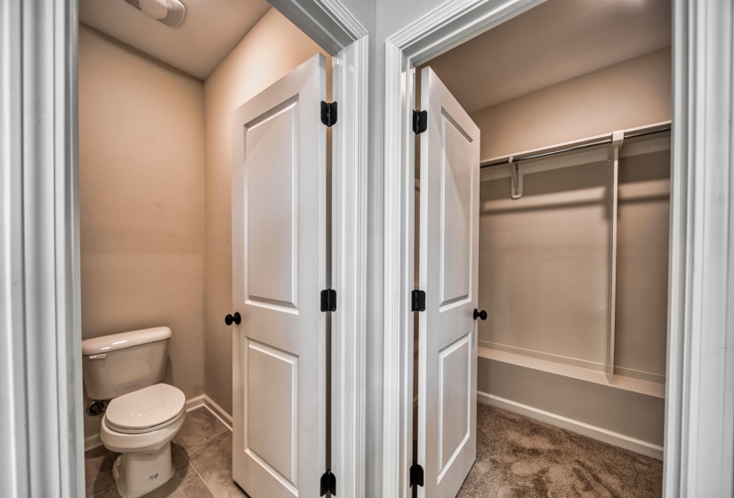 Bathroom with toilet and dark tile patterned flooring