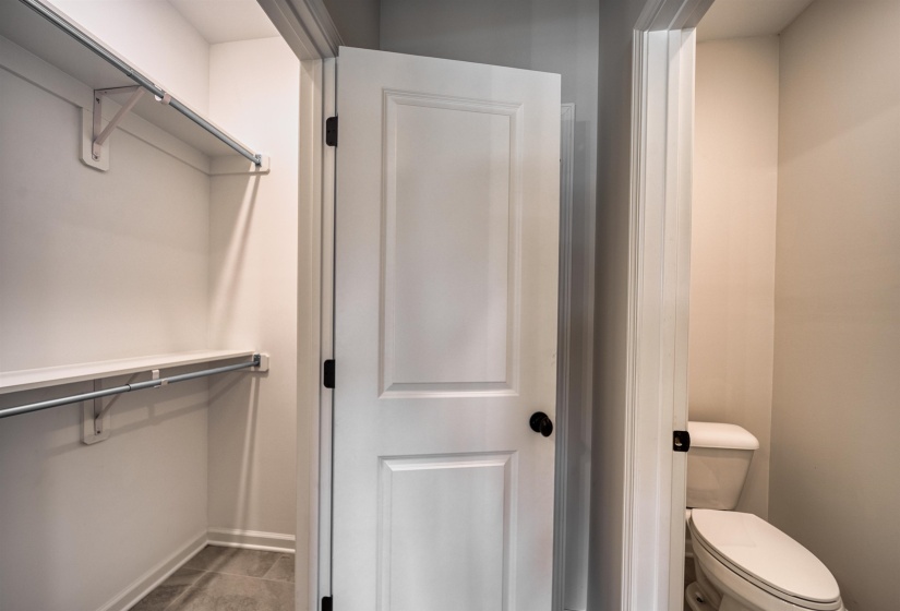 Bathroom with a spacious closet and baseboards