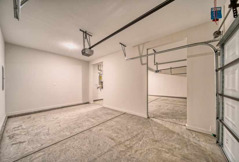 Garage with baseboards and a garage door opener