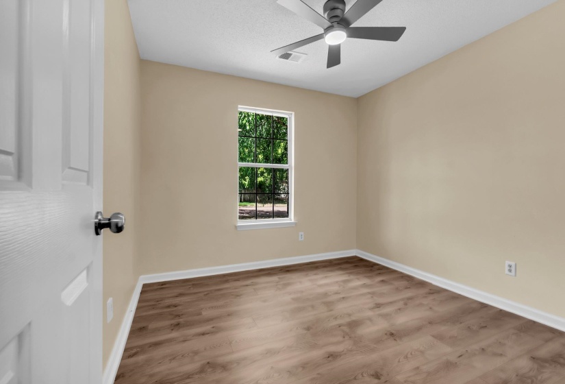 Room featuring wood-finish flooring, neutral wall paint, and white baseboards