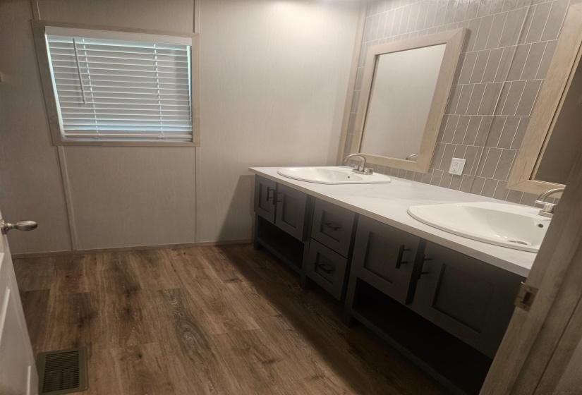 Dual vanity featuring integrated sinks, dark cabinetry, and light countertops