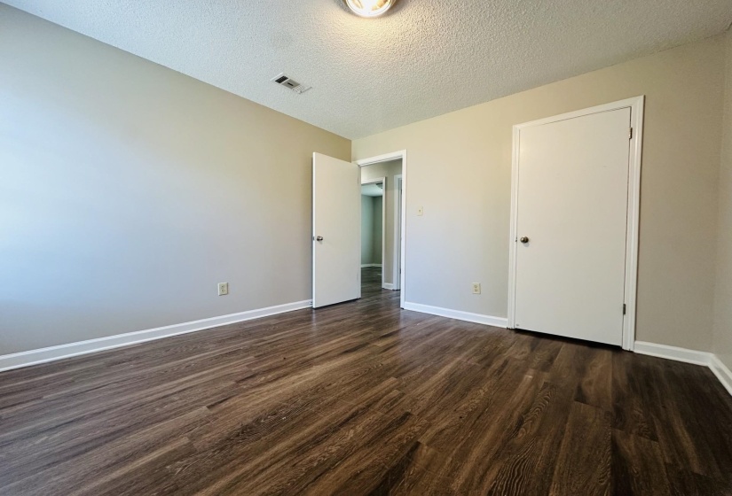 Interior space featuring wood-finish flooring, light neutral wall paint, and white trim molding