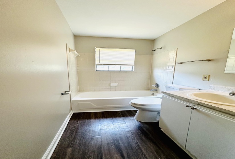 Bathroom featuring a white bathtub, toilet, and a white vanity with a light-colored countertop