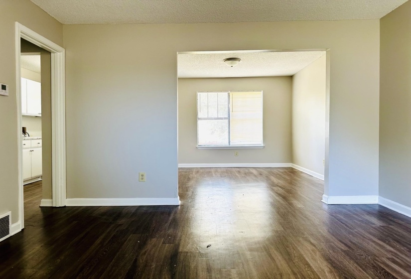 Interior space featuring wood-finish flooring, neutral wall paint, and white baseboards