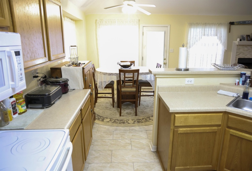 Kitchen featuring wood-finish cabinetry, solid surface countertops, a built-in microwave, and an electric range