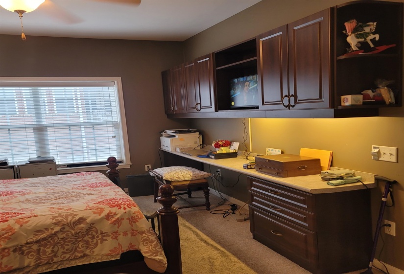Built-in desk area featuring an extended countertop, under-cabinet lighting, and integrated dark wood cabinetry