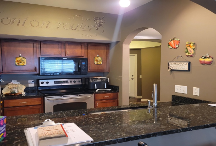 Kitchen featuring dark wood cabinetry, a stainless steel range, and a built-in microwave