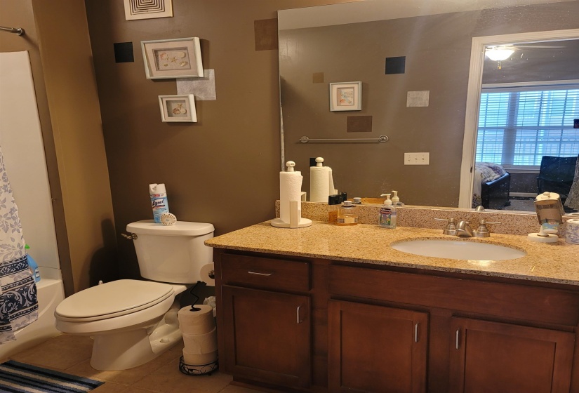 Bathroom vanity featuring a light granite countertop and an undermount sink