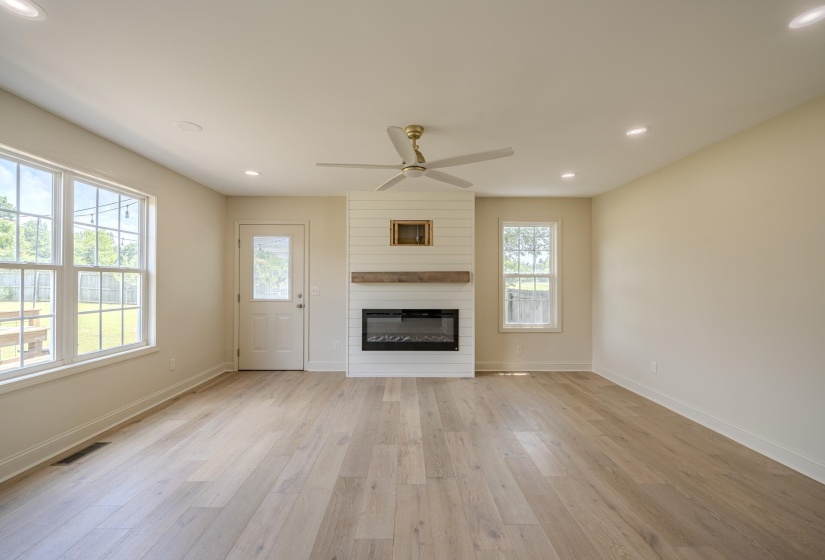 Spacious interior featuring wide plank wood-finish flooring, recessed lighting, and a modern ceiling fan