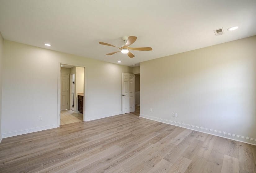 Spacious room featuring wood-finish flooring, recessed lighting, and a ceiling fan