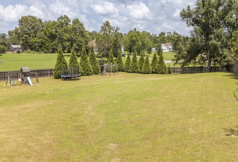 Expansive grassy lawn with a wood-fenced perimeter
