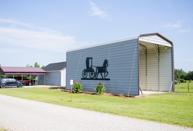 Steel-framed carport featuring a corrugated metal roof and a separate metal storage structure