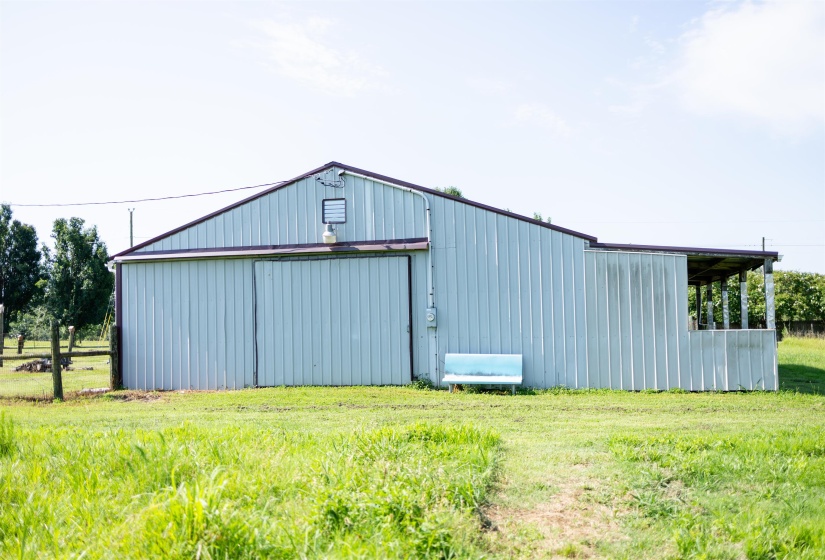 Metal-sided barn structure featuring a gable roof and an attached covered porch