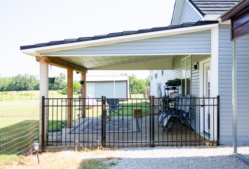 Expansive covered deck featuring natural wood columns and a black metal railing