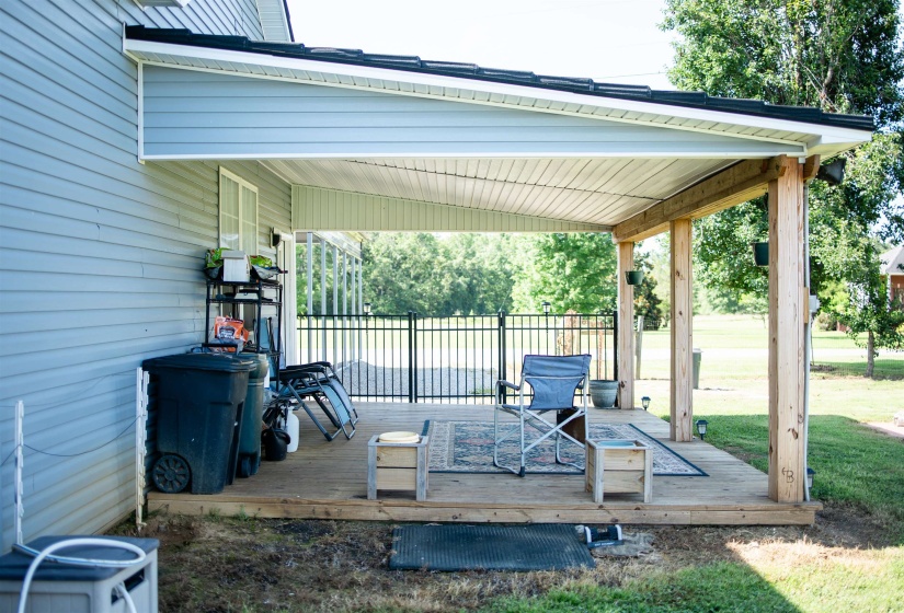 Covered wooden deck featuring natural wood support posts and a white soffit ceiling