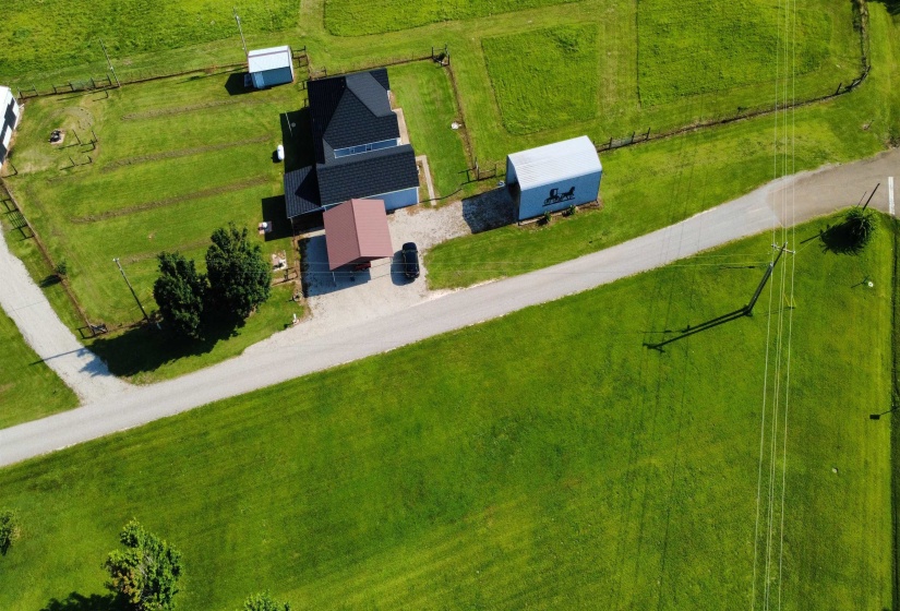 Aerial property view featuring a residence, detached garage, and multiple outbuildings
