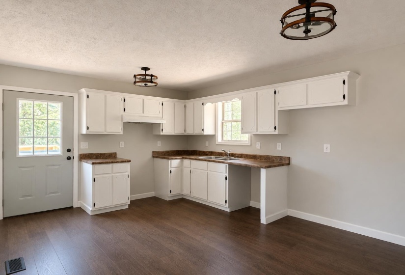 Kitchen featuring white cabinetry, wood-finish flooring, and a double-basin sink